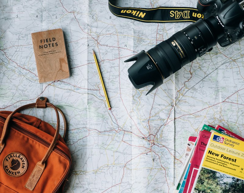 Paper map, notebook and camera laid out while planning a January itinerary