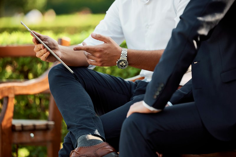Two travel consultants reviewing entry requirements on a tablet